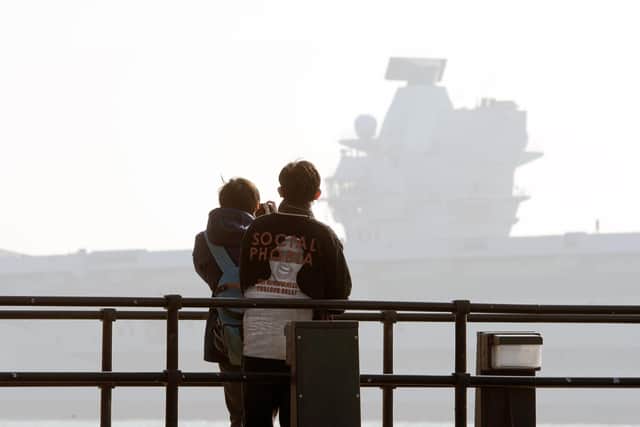 A couple watch HMS Queen Elizabeth leaving Portsmouth on Monday, March 1.Picture: Sarah Standing (010321-1750)