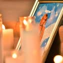 Candles are placed in front of a photo of cinematographer Halyna Hutchins during a vigil in her honor at Albuquerque Civic Plaza on October 23, 2021 in Albuquerque, New Mexico. Hutchins was killed on set while filming the movie "Rust" at Bonanza Creek Ranch near Santa Fe, New Mexico on October 21, 2021. Photo by Sam Wasson/Getty Images)