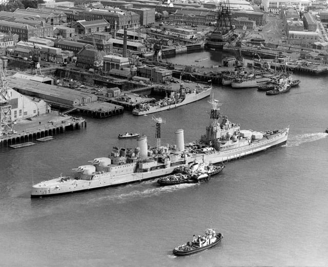 The Royal Navy Town-class light cruiser HMS Belfast under tow from tugboats passes the18th century 104-gun first-rate ship of the line and Admiral Lord Nelson's flagship HMS Victory on her last voyage from Portsmouth Dockyard to her new berth in London as a floating museum on 2 September 1971 in Portsmouth, United Kingdom. (Photo by Keystone/Hulton Archive/Getty Images).