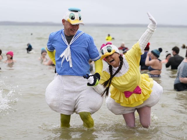People take part in the Gosport New Year's Day Dip in The Solent at Stokes Bay, Gosport, Hampshire, to raise money for Gosport and Fareham Inshore Rescue Service.