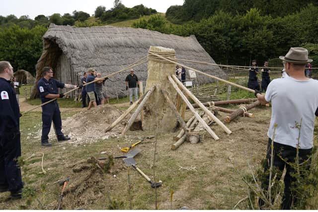 Crew members from HMS Queen Elizabeth and volunteers help raise a 3.5 ton standing stone, using only traditional methods, at Butser Ancient Farm to mark its 50 year anniversary