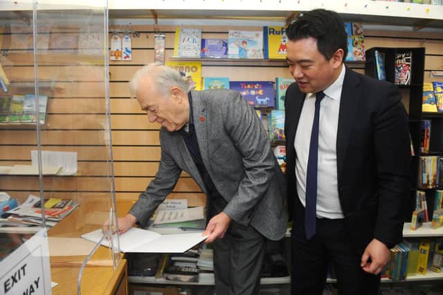 Amateur photographer Pietro Rocchiccioli (74) from Hayling Island, has created a book documenting Hayling Island during the Covid-19 pandemic first lockdown. Pictured is: Pietro Rocchiccioli signing a copy of his book for Alan Mak MP for Havant.Picture: Sarah Standing (040322-166)