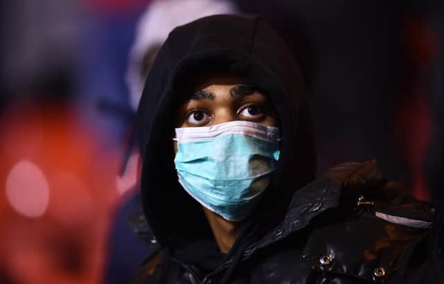 A fan at a football match wears a face mask as protection from Coronavirus. Picture: Nathan Stirk/Getty Images