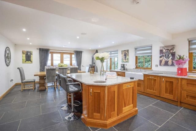 The kitchen features a large central island with solid granite worktop and boiling water tap, as well as a double Belfast sink.