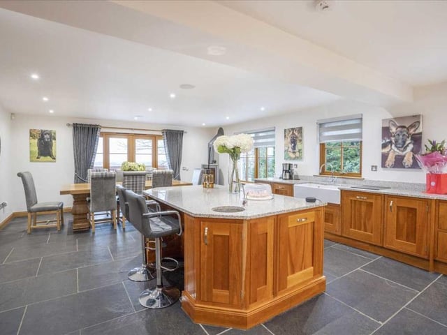 The kitchen features a large central island with solid granite worktop and boiling water tap, as well as a double Belfast sink.