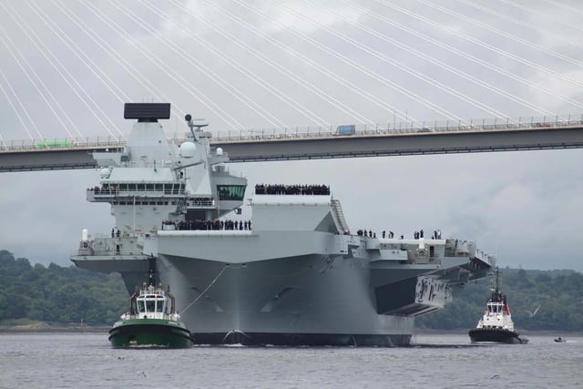 HMS Queen Elizabeth leaving Rosyth in Fife, Scotland, and sailing under the Forth bridge. She is due to return home to Portsmouth on July 30.