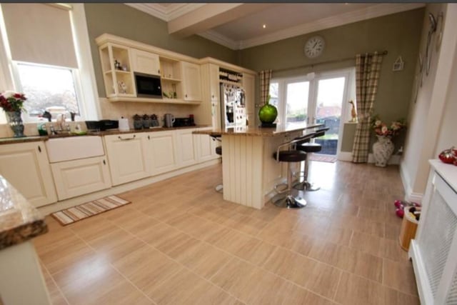 The airy kitchen features granite work surfaces and an island unit. 
Image by Andrew Craig.