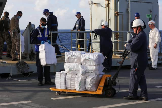 Members of RFA Argus's crew, 1700 Naval Air Squadron, United States Coastguard and Commandos of 539 Raiding Boat Squadron Royal Marines unloading narcotics onto the flight deck of RFA Argus during interdiction in the Caribbean Sea  Photo: Royal Navy