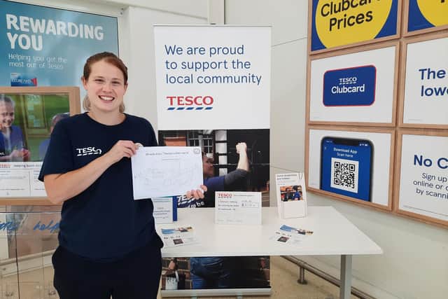 Tesco Fratton Way Community Champion Gemma Morrison with a picture of Ninah the police van for kids to colour in.