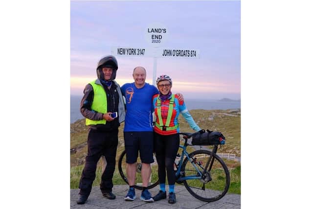 Marcia Roberts has become the first woman to complete the cycle from Land's End to John o'Groats and back again. Pictured: Marcia at the finish line with her motorcycle outrider Steve Moir and husband Del Roberts