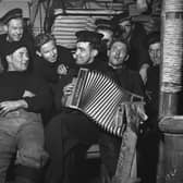 Crew members listening to the accordion below decks on a Royal Navy minesweeper during World War II, March 1941.  (Photo by Horace Abrahams/Keystone Features/Hulton Archive/Getty Images)