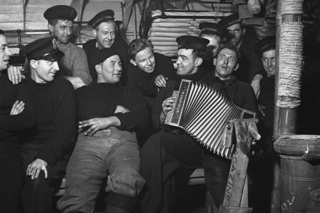 Crew members listening to the accordion below decks on a Royal Navy minesweeper during World War II, March 1941.  (Photo by Horace Abrahams/Keystone Features/Hulton Archive/Getty Images)