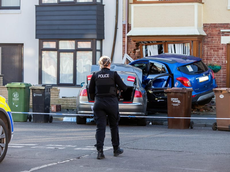 Police presence on Kensington Road with 2 damaged cars against a house.