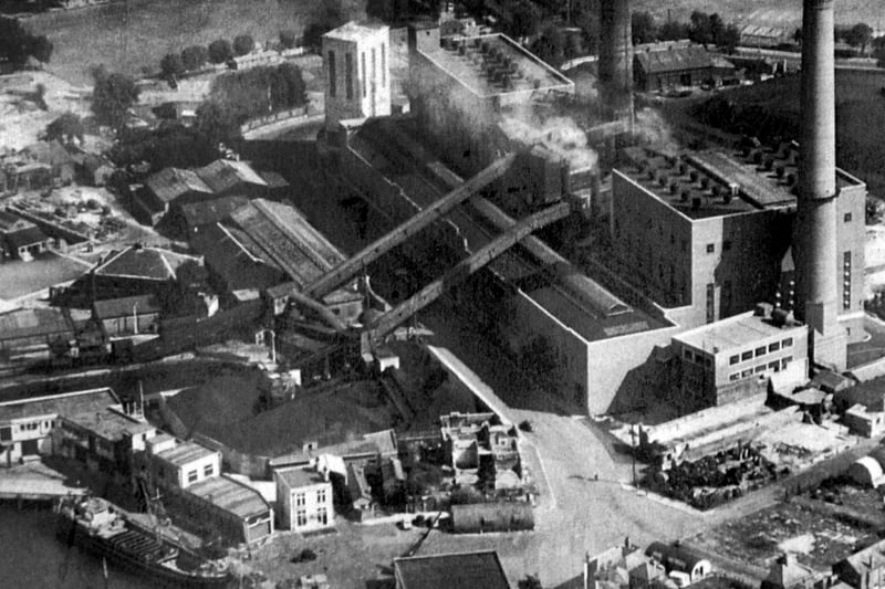 Old Portsmouth Power Station circa 1948. To the bottom left is the Camber  with the cola hoppers of Whites the coal merchant. Unloading at the wharf is a large collier with three barges alongside. At the pointed end of the coal wharves can just be seen the Bridge Tavern which is dwarfed by them. Above the Bridge Tavern is the lock for the coal barges that brought in coal for the power station.

The covered travellators for taking the coal up and over Gunwharf Road can be seen. Above the lock are the buildings of HMS Vernon. To the bottom right can be seen Oyster Street which at this time  passed into White Hart Lane and since these times a block of flats have been built over it.
St Thomas Street passes behind the cathedral with many of the buildings just bomb sites. The bank now a residential building on the corner of Highbury Street can be Cleary seen.
 
The east end of St Thomas's Street and Warblington Street leaading into St Georges Road close by Landport Gate are both bomb sites.
 
To the top right hand corner can be seen the United Services cricket ground where, up until the Rose Bowl was built, Hampshire played first class cricket.  
Above the power station chimneys the railway line from the Harbour station to Portsmouth & Southsea High Level can be seen running along its tree lined route.