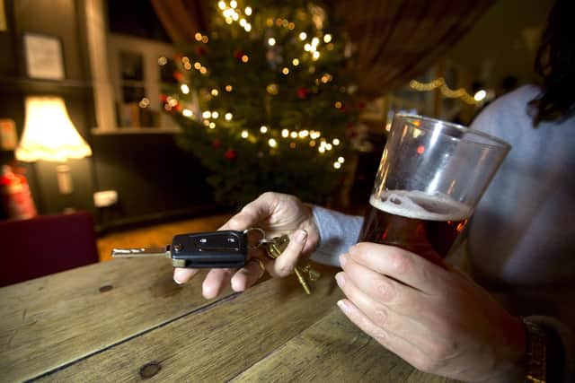 A woman holding car keys and a pint of larger in a pub. Yui Mok/PA Wire