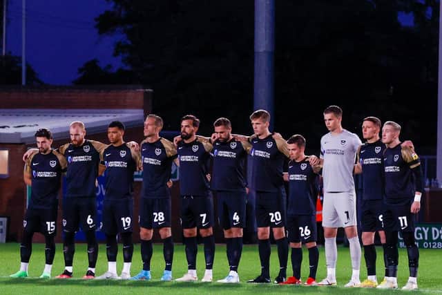 The diminutive Tom Lowery and his Pompey team-mates observe a minute's silence at Burton Albion.