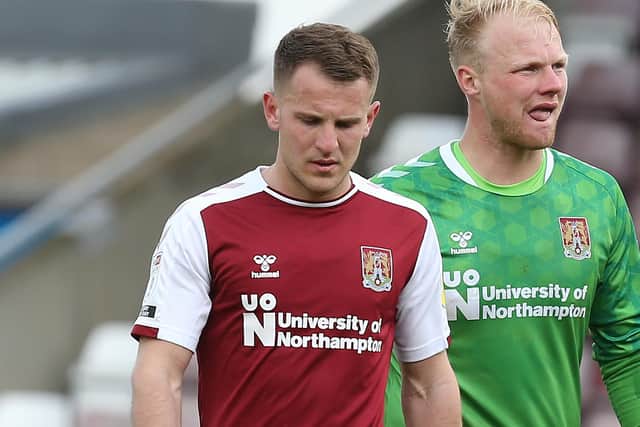 NORTHAMPTON, ENGLAND - MAY 01: Bryn Morris and Jonathan Mitchell of Northampton Town walk from the pitch at the final whistle after defeat confirmed that Northampton Town were relegated during the Sky Bet League One match between Northampton Town and Blackpool at PTS Academy Stadium on May 01, 2021 in Northampton, England. (Photo by Pete Norton/Getty Images)