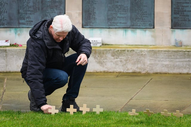 Pictured is: A member of the public places a cross at the Southsea Naval War Memorial

Picture: Keith Woodland (121121-9)