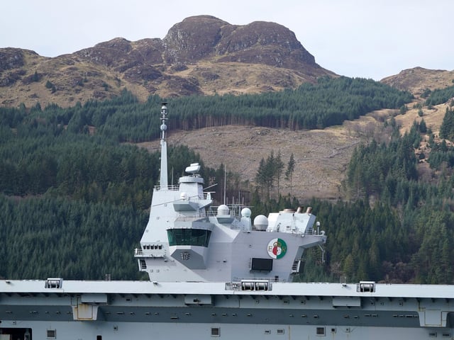 The Royal Navy aircraft carrier HMS Queen Elizabeth leaving Glen Mallan in Loch Long with the Arrochar Alps behind.