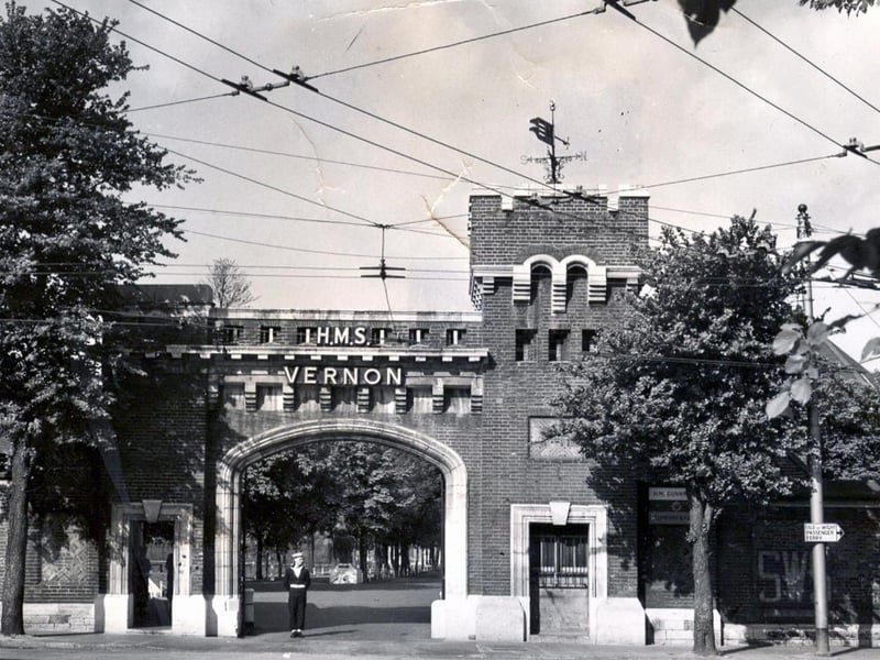 HMS Vernon main gate. Taken some time in the late fifties /early sixties we see the main gate to HMS Vernon. The very attractive entrance is enhanced by the trees, now cut down, and the avenue seen just inside the gate. On the wall to the right can bee seen the letters in yellow SWS. This pointed to the location of a static water supply during the war. The letters can still be seen on many house walls within the city. Overhead can be seen the trolleybus wires from Park Road.