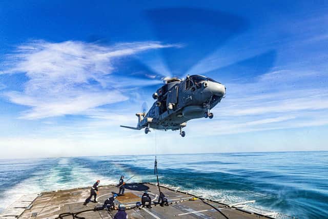 A Merlin helicopter hovers above Portsmouth-based frigate HMS Westminster to be refuelled. Photo: Royal Navy