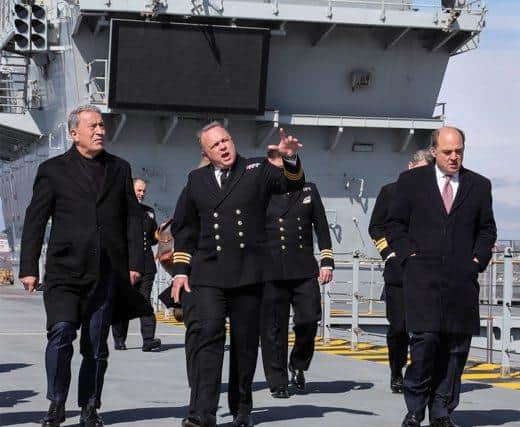 Image of Commander Air, Philip Beacham (centre), leads a tour of the flight deck of HMS Prince of Wales in Portsmouth with Turkish defence minister Hulusi Akar (left). UK defence secretary Ben Wallace is pictured, right. Photo:MoD