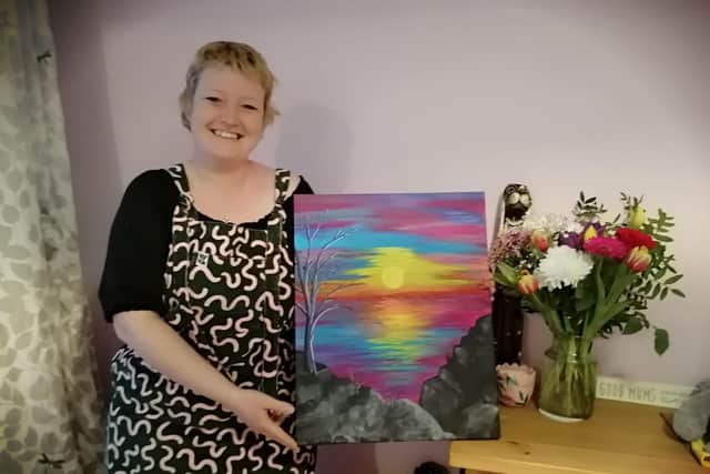 Jemma Reed from Fareham is raffling off one of her paintings for the oncology department at Queen Alexandra Hospital after they looked after her while having breast cancer treatment. Pictured: Jemma with the sunset painting
