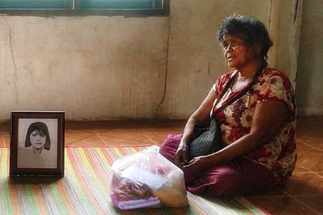 Jumsri Seekanya sits by a picture of her daughter Lamduan, at her home in Phen district, Udon Thani,  (Photo by Yuttapong Kamnodnae/Bangkok Post)