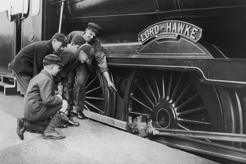 An engine driver showing a group of schoolboys over the Lord Nelson Class locomotive, Lord Hawke, during a train exhibition at Portsmouth Town Station, 21st October 1933. (Photo by J. A. Hampton/Topical Press Agency/Hulton Archive/Getty Images)