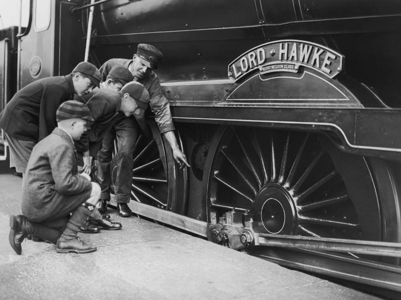 An engine driver showing a group of schoolboys over the Lord Nelson Class locomotive, Lord Hawke, during a train exhibition at Portsmouth Town Station, 21st October 1933. (Photo by J. A. Hampton/Topical Press Agency/Hulton Archive/Getty Images)