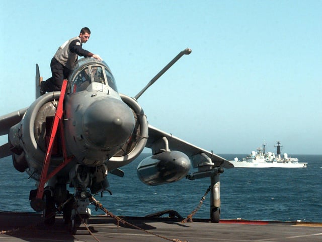 AEM Alan Clements from Taunton readies a Sea Harrier on HMS Invincible with escort HMS Newcastle (in background) Saturday April 17, 1999, as the aircraft carrier joins NATO forces off the Balkan coast. PA photo: Tim Ockenden