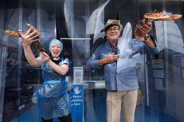 Business owner Chantelle Williams and artist Guy Venables launch Fresh From The Boat's competition to win fish. Readers are invited to spot the puns in Guy's fishy cartoons. Pictured at Fresh From The Boat seafood shop, Emsworth Yacht Harbour. Picture: Chris Moorhouse (jpns 290721-35)