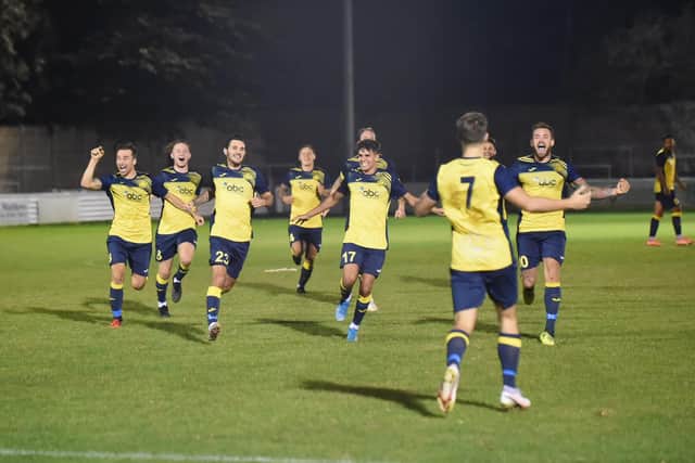 Moneyfields players rush to congratulate Joe Briggs (7) after the latter's winning penalty in the shoot-out at Aylesbury United. Pic: Michael Snell.