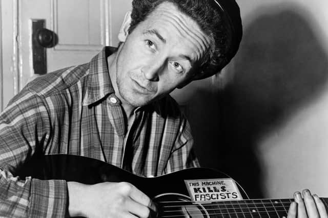 Woody Guthrie with his guitar and its famous message: 'This machine kills fascists'