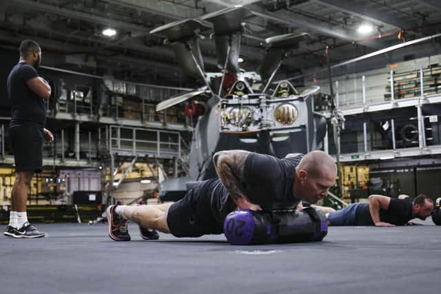 HMS Queen Elizabeth's ship's company take part in circuits in the hangar. Picture: LPhot Belinda Alker.