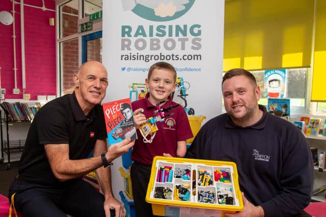 Albert McCormick, 8, born with only one arm, is a pupil at Rowner Junior School, in Gosport. He is being gifted a book and £300 worth of Technic Lego by Stephen Shaw, a Lego trainer at his school. Pictured: Stephen Shaw with Albert McCormick and his dad, Joseph McCormick, at Rowner Junior, Gosport on November 9. 2022. Picture: Habibur Rahman