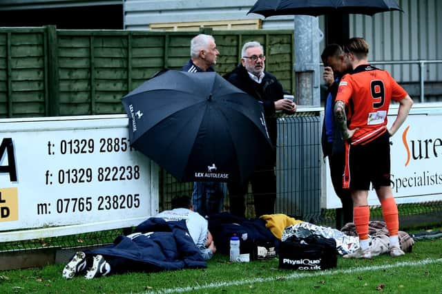 Bailey Honeysett is comforted by physios as he waits for an ambulance. Picture by Tom Phillips