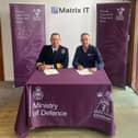 Nic Cronin (right) signing the Armed Forces Covenant