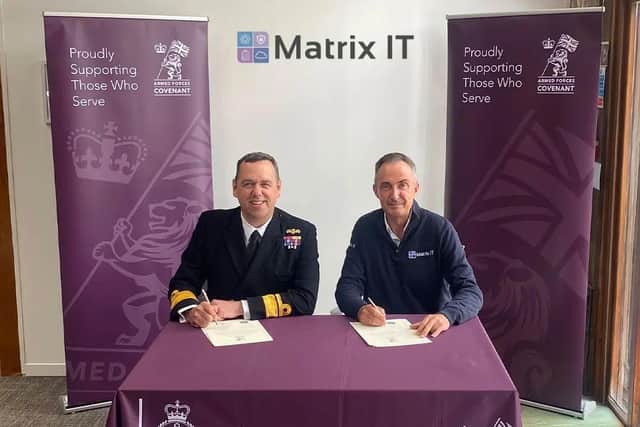 Nic Cronin (right) signing the Armed Forces Covenant