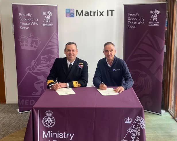 Nic Cronin (right) signing the Armed Forces Covenant