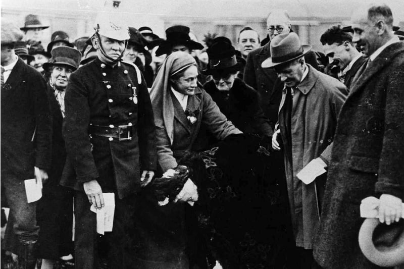 100 year old Miss Bannister symbolically begins the construction of the hospital on 16 November 1927. Nurse Anderson is on the fireman's left. 
Picture: Hampshire Library and Information Service.