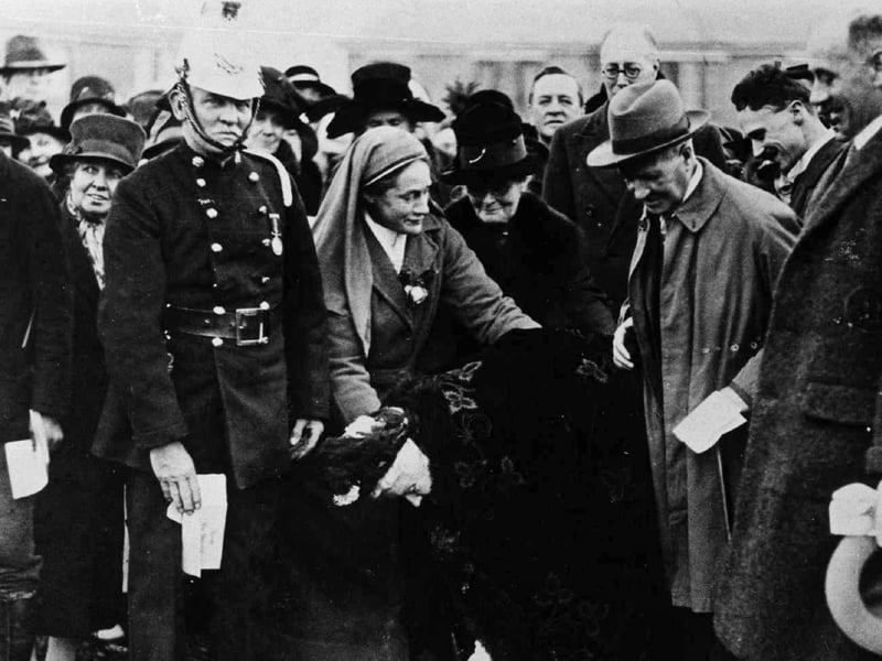 100 year old Miss Bannister symbolically begins the construction of the hospital on 16 November 1927. Nurse Anderson is on the fireman's left. 
Picture: Hampshire Library and Information Service.