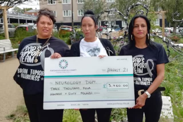 Sasha Clarke pictured with sisters Hayley, right, and Hannah, left, as they hand in a charity cheque to Queen Alexandra Hospital's neurology department.