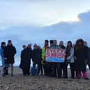 Frances Vigay (holding the sign) on the morning of December 31, 2023, with friends and supporters of her Every Sunrise project on Southsea beach