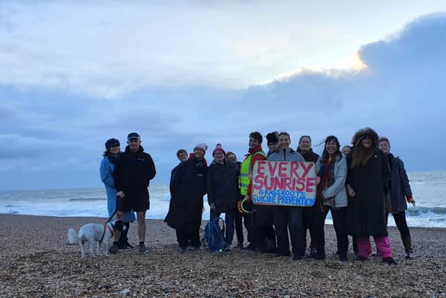 Frances Vigay (holding the sign) on the morning of December 31, 2023, with friends and supporters of her Every Sunrise project on Southsea beach