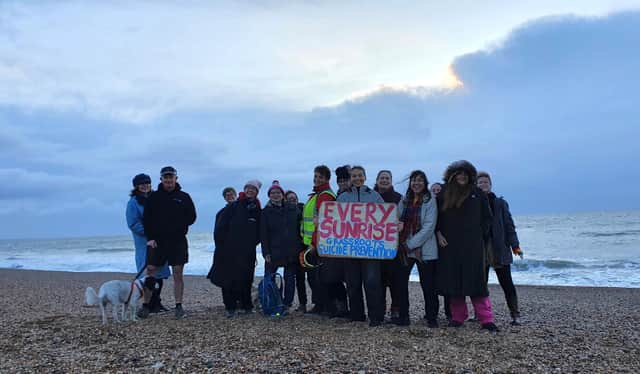 Frances Vigay (holding the sign) on the morning of December 31, 2023, with friends and supporters of her Every Sunrise project on Southsea beach