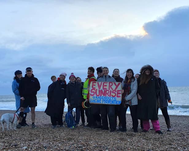 Frances Vigay (holding the sign) on the morning of December 31, 2023, with friends and supporters of her Every Sunrise project on Southsea beach