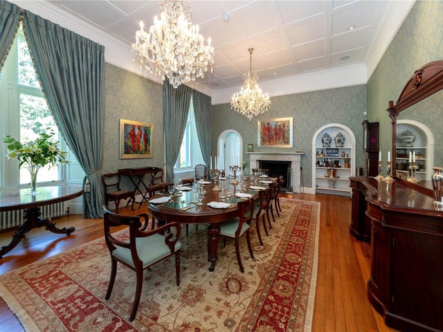 The dining room has a decorative ceiling pattern, with an impressive open fireplace, as well as exposed timber flooring and traditional sash and case windows with a mirroring archway that leads to the drawing room