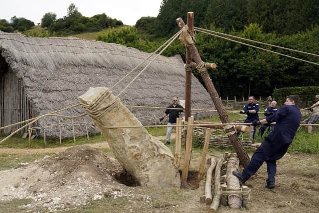 Crew members from HMS Queen Elizabeth and volunteers help raise a 3.5 ton standing stone, using only traditional methods, at Butser Ancient Farm to mark its 50 year anniversary