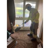 A firefighter from Portchester Fire Station cleaning up broken glass. They broke into the property so paramedics could reach an elderly woman who had a fall, in Quintrel Avenue, Portchester. Picture: Portchester Fire Station.
